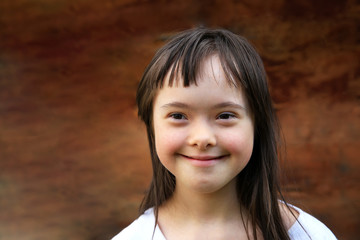 Portrait of little girl smiling on brown background