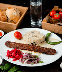 rice with meat, onions and a glass of water