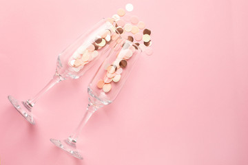 Champagne glasses with pink and gold confetti on pink color paper background minimal style with copyspace