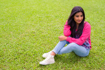 Happy young beautiful Persian woman relaxing at the park