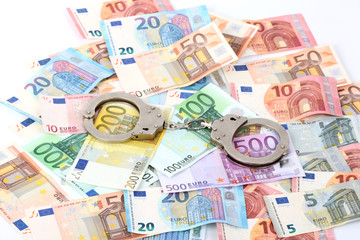 silver handcuffs on many large euro notes