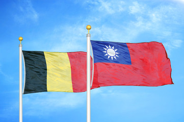 Belgium and Taiwan two flags on flagpoles and blue cloudy sky
