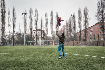 dad tosses the baby up on the playground