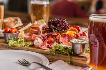 Plato de carne y queso de tapas tradicionales españolas - chorizo, salsichón, jamón serrano, lomo y rodajas de queso de cabra