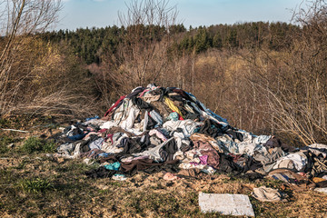 heap of clothes garbage in the forest