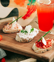 snack sandwiches on the table with red cocktail