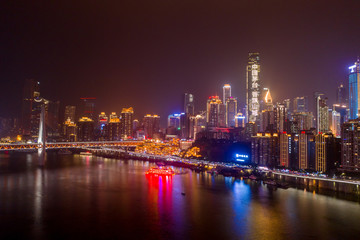 Obraz premium Aerial view of Hong Ya dong Cave, Historic Chinese folk religion town by Jialing River with lighted skyscrapers