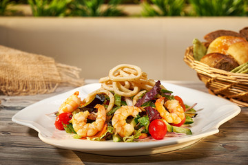 Hot snack. Warm salad with shrimps, fresh herbs and vegetables