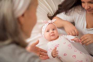 Cute baby girl looking at her grandmother