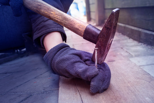 Man Hammering A Nail With A Hammer. A Blow On The Finger. Pain In The Arm