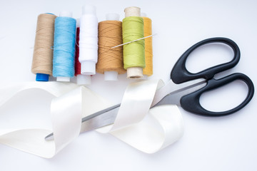 Accessories for needlework thread, tape, scissors on a white background,