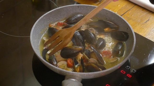 Preparing basic dressing for pasta allo scoglio in a non stick pan