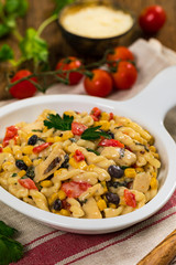 Grilled Chicken Alfredo Pasta with Black Beans, Corn and Red Peppers on Wooden Background. Selective focus.