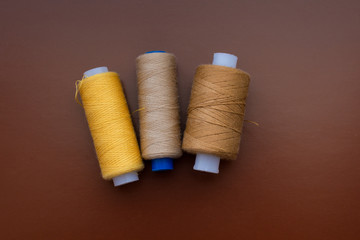 Babin sewing thread on a brown isolated background, top view