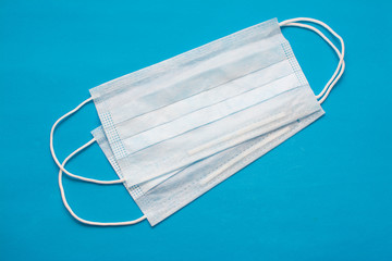 Medical protective mask on a blue background. Disposable surgical mask covering the mouth and nose. Healthcare and medicine concept. Virus protection.