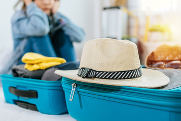 focus vintage hat on suitcase with woman hipster traveler sad after flight cancelled with packing...