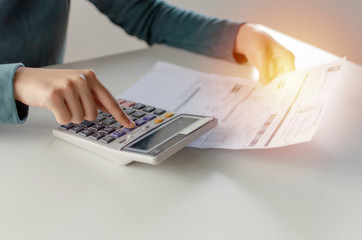 hand of young woman using calculator for calculating family budget cost bills on desk in home office, calculate, plan money cost saving, investment, business finance, expenses, income concept