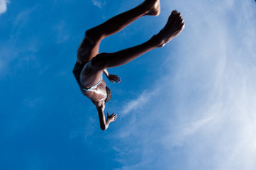 menino pulando com céu ao fundo