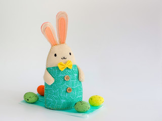 bunny and Easter eggs on a medical mask on white background. close up. celebrating Easter during the coronavirus..