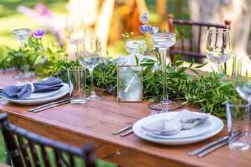 Preparing for an open-air party. Decorated with fresh flowers served tables. Table number. Decoration Details
