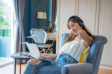 Asian woman is working with a laptop, working from home and feeling pain in the neck.
