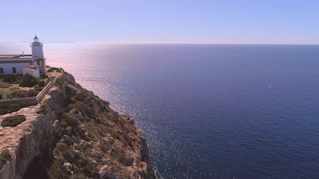 Lighthouse on rocky seashore with curved road