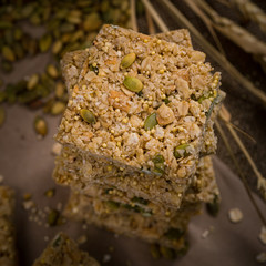 Multigrain Cereal Crunchy Squares Bars with Pumpkin Seeds Background. Healthy Bar Snack. Selective focus.
