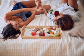 Romantic couple enjoying together at bed.Red rosses for my love girlfrend. © luckybusiness