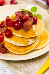 Healthy Homemade Classic American Pancakes with Sliced Red Grapes and Maple Syrup Close Up. Selective focus.