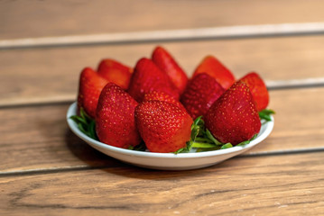 tiernas fresas fresca sobre un plato de color blanco en una madera