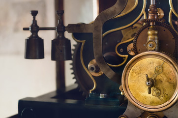 detail of an antique clock working mechanism from the XIX century with golden cogwheel and weight...