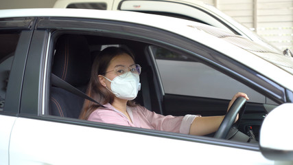 Asian women waring surgical face mask before driving. The COVID-19 is affecting many countries and territories around the world