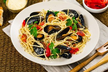 Delicious Seafood Pasta Spaghetti with Mussels and Tomatoes on Wooden Background. Italian Cuisine. Selective focus.