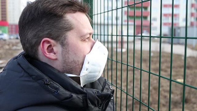 Man in the medical mask in empty city street. Pandemic and epidemic. European man standing near state border. Prohibition of entry and exit into the country.