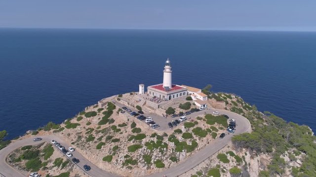 Lighthouse on rocky seashore with curved road