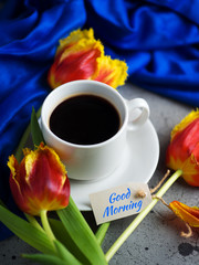 Good spring morning a Cup of coffee on the table with red tulips