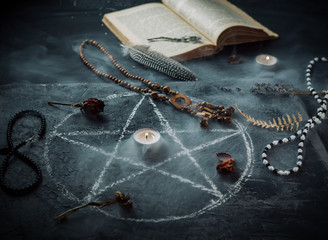 Mystical still life with books on ancient magic, pentagram, candles and symbols