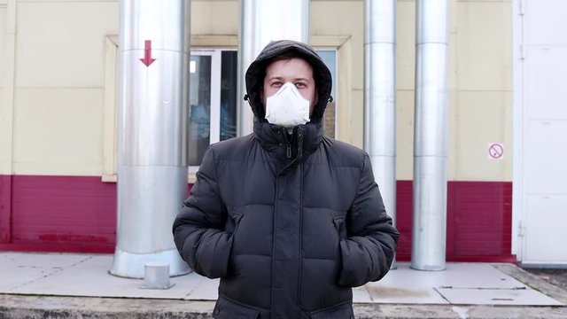 Man in the medical mask in empty city street. Pandemic and epidemic. European man standing near state border. Prohibition of entry and exit into the country.