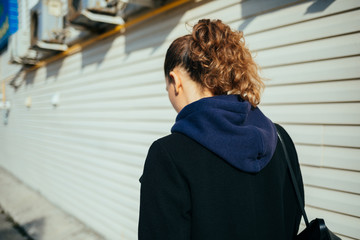 Back view young woman wearing coat and hooded sweatshirt