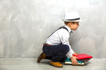 Elementary school student carrying notebooks over a gray background