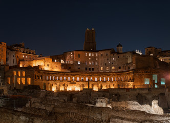Fototapeta premium Trajan's Market, Via dei Fori Imperiali, Rome, at the opposite end of the Colosseum. The ruins overlook a splendid night view of the Forum of Trajan and the Vittoriano. 