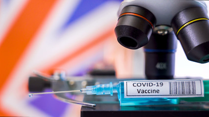 Obraz na płótnie Canvas Closer look of the vaccine syringe for COVID-19 coronavirus vaccines UK flag