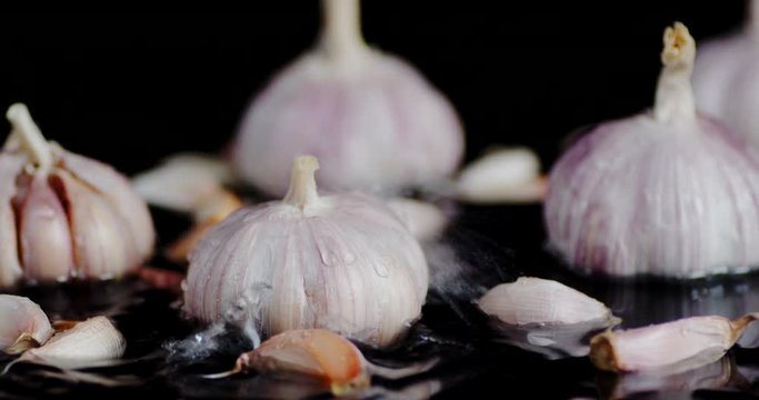 The heads and cloves of garlic falling water drops.