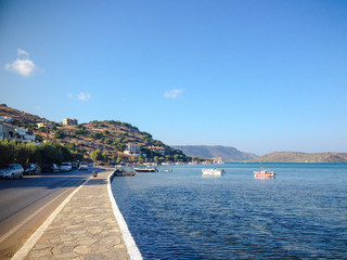 Fototapeta na wymiar Elounda, Crete, Greece - September 2: path along the sea. Near the road on which cars go.