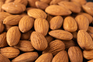 Background of large raw peeled almonds placed randomly. Close up. Food background