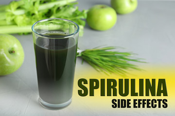 Glass of spirulina drink on grey background. Side effects