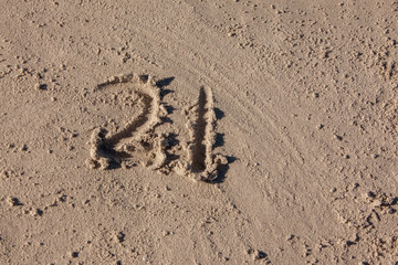 Fototapeta na wymiar the number 21 written on beach sand