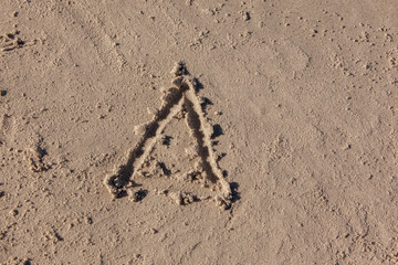 triangle drawn on beach sand