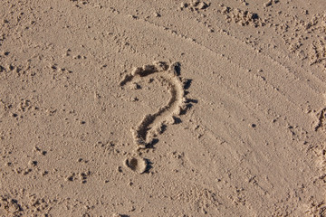 Fototapeta na wymiar question mark written on beach sand