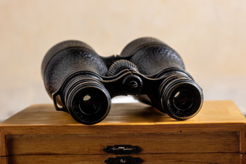 Classic binoculars on top of a wooden box.